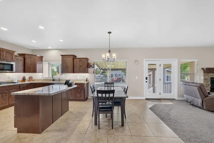 Kitchen featuring recessed lighting, a central island with a stone-finish countertop, wood cabinetry, and stainless steel appliances