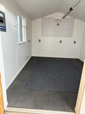 Slatted panel walls, a multi-pane window, and checker plate flooring