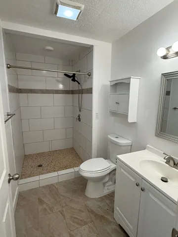 White subway tile shower with a mosaic floor