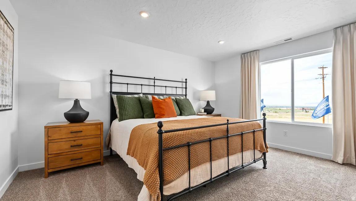 Recessed ceiling lighting, large window with expansive outdoor scenery, neutral wall paint, and textured carpet flooring