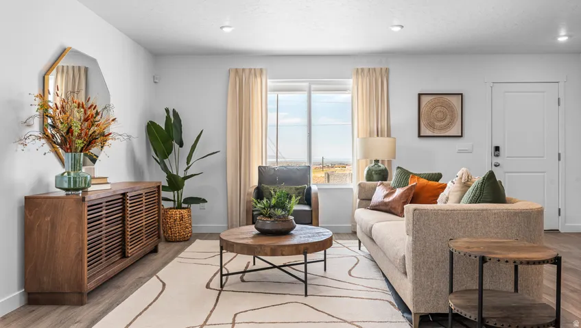 Recessed lighting illuminates wood-finish flooring and a bright window