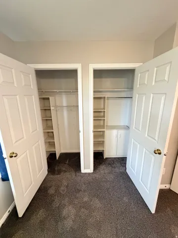 Dual closet system featuring built-in shelving and hanging rods