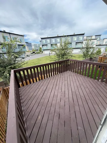 Expansive outdoor deck with wood railing, offering elevated views of the surroundings