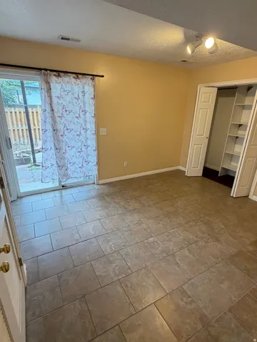 Tiled flooring, track lighting, sliding glass door, built-in shelving