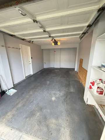 Attached garage space with painted concrete flooring and overhead lighting