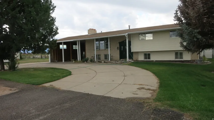 Split-level residence featuring a concrete driveway and brick detailing