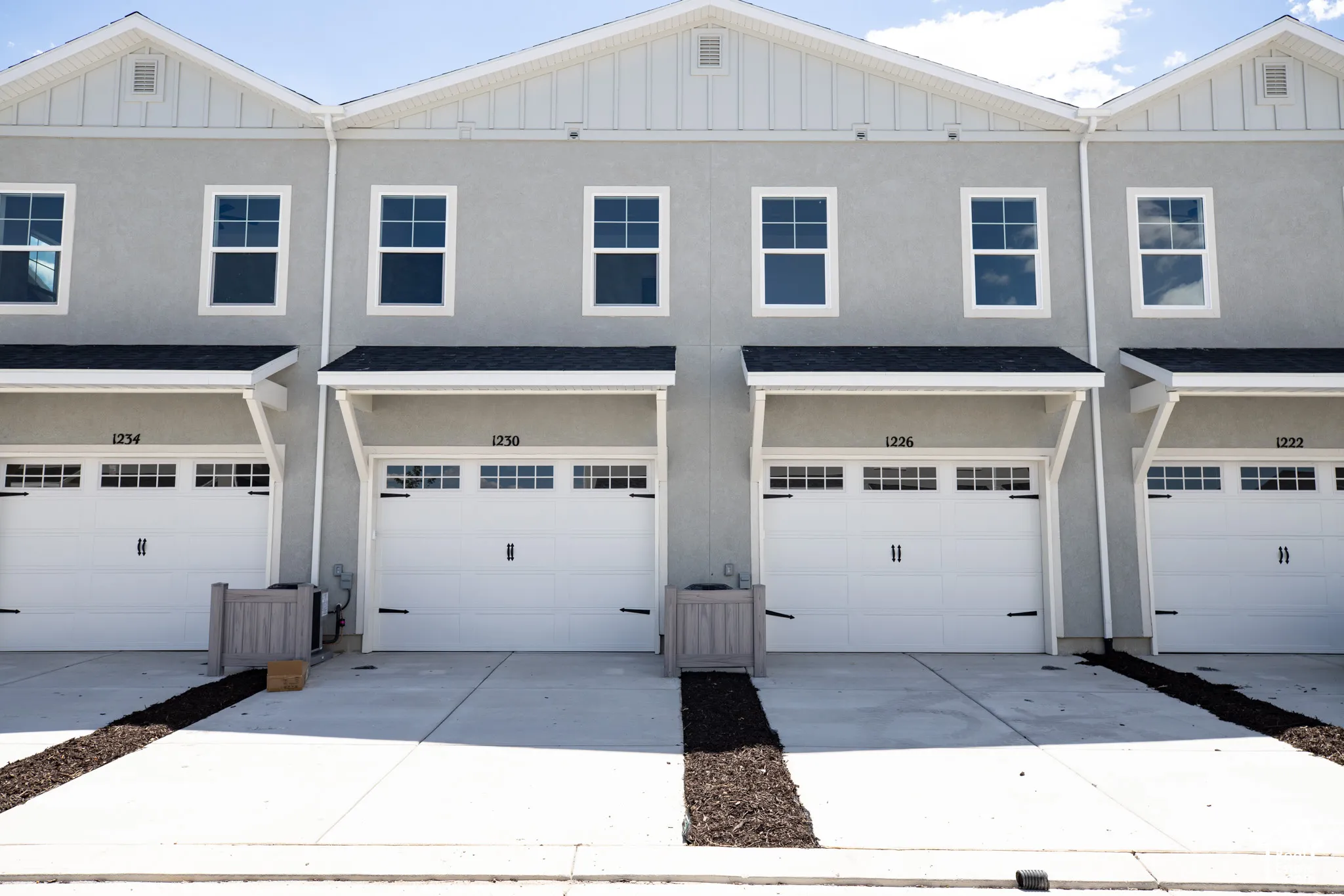 Rear view of townhome with garage and extended driveway.