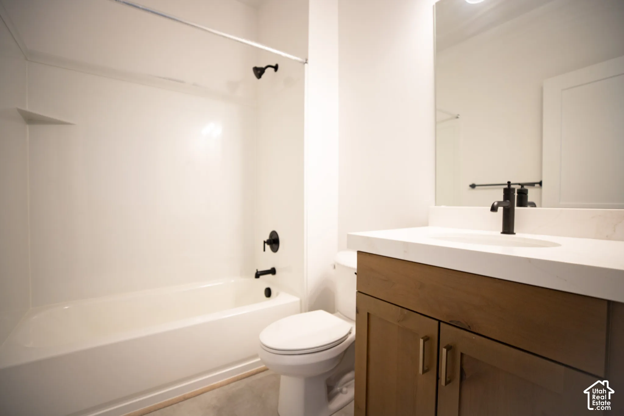 Full secondary bath with stained wood cabinets and quartz slab countertop.