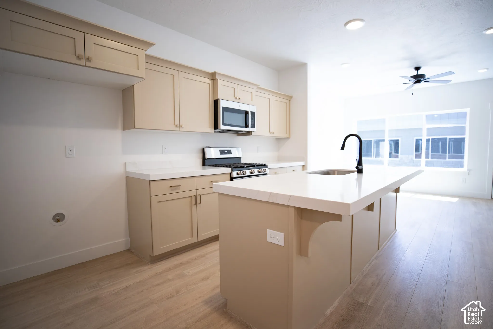 Terrific kitchen with painted wood cabinets and island, quartz slab countertops, gas range, dishwasher, microwave and disposal.