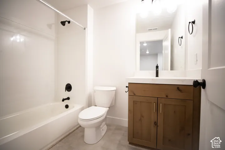 Third full bath in fully-finished basement with stained wood cabinet and quartz slab countertop.