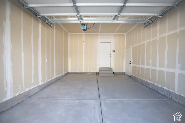 One-car garage with extra space for storage and taped finish.