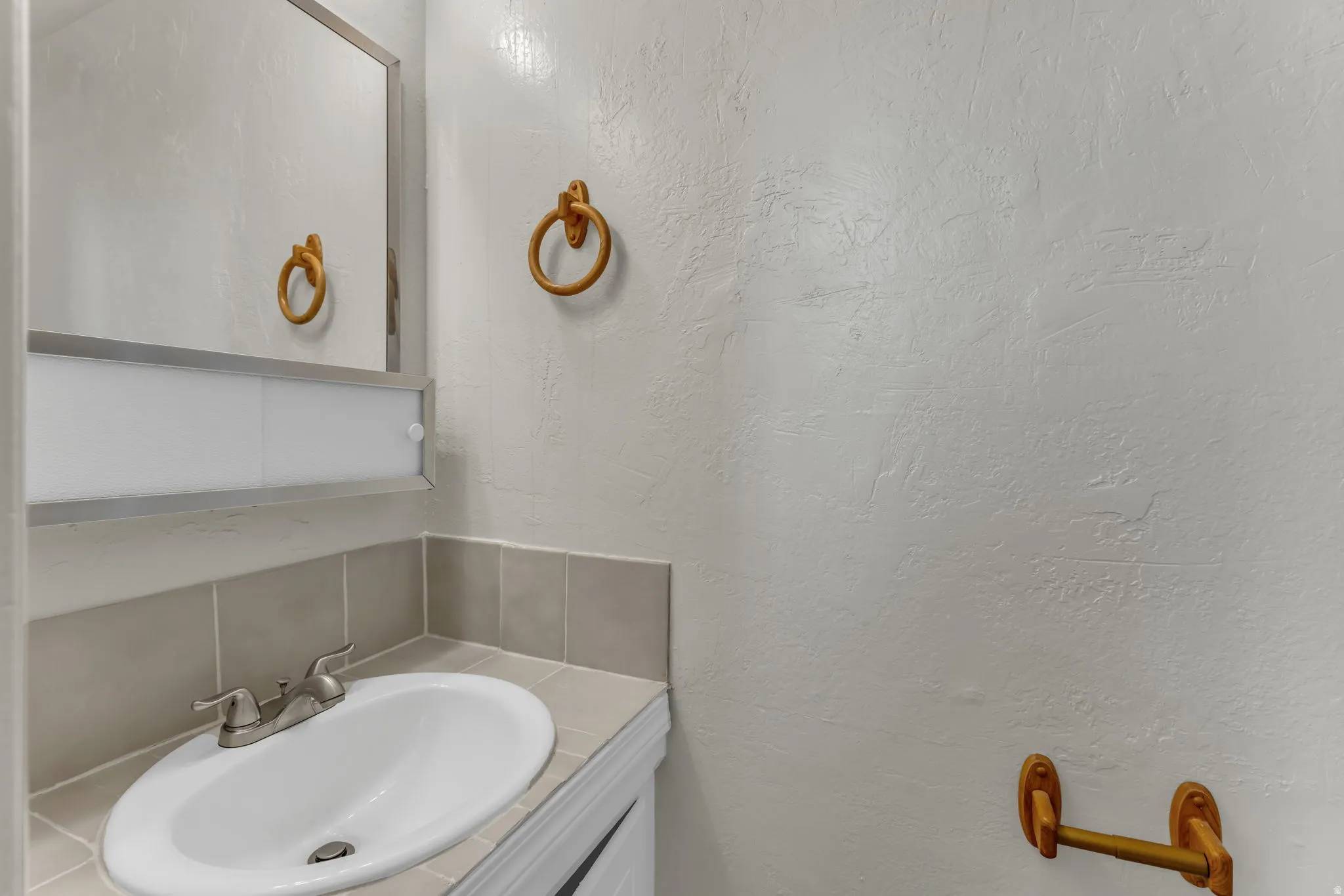 Oval undermount sink with a chrome-finish faucet, set into a tile countertop
