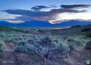 Expansive land lot featuring distant mountains and a distant cityscape