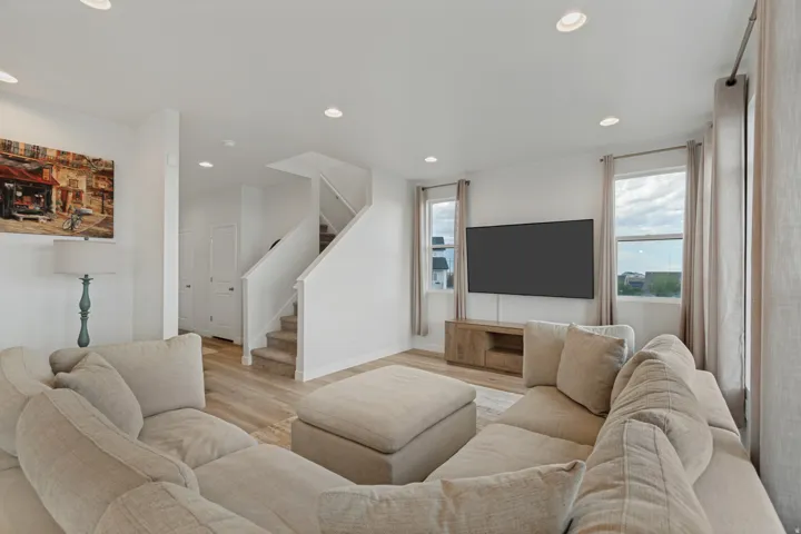 Open-concept living space featuring recessed lighting, wood-finish flooring, and multiple windows