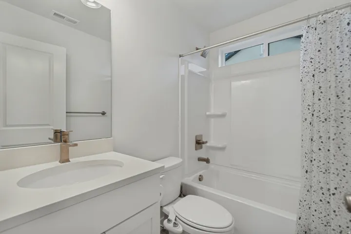 White vanity with an integrated sink and bronze-tone faucet