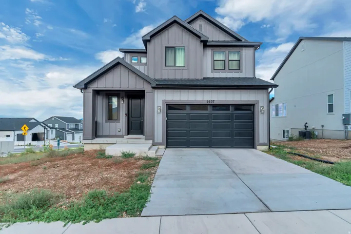 Contemporary exterior with board and batten siding, attached two-car garage, covered entry, and multiple window configurations