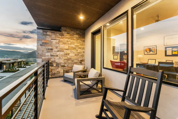 Balcony featuring a stone accent wall, recessed lighting, a wood-finish ceiling, and metal railings