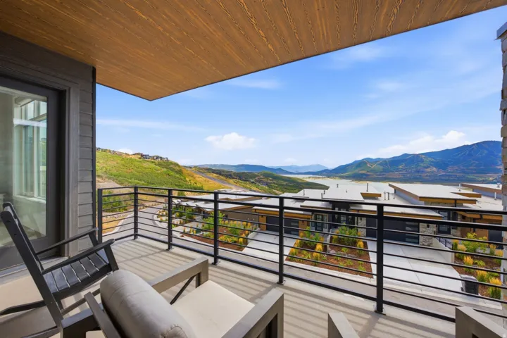 Balcony with wood-finish ceiling, metal railing, and expansive mountain scenery