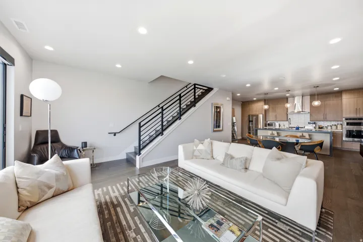 Open concept living area featuring dark wood-finish flooring, recessed lighting, and a modern kitchen