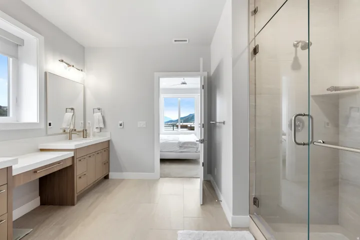 Walk-in shower with clear glass enclosure and tile surround