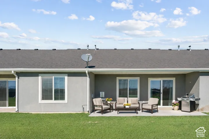 Patio with a concrete surface, multiple sliding glass doors, white window trim, and a dark shingle roof