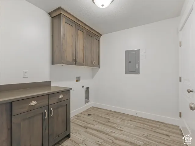 Wood-finish flooring, built-in cabinetry, solid surface countertop, overhead lighting, and a paneled door