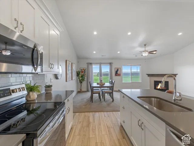 Vaulted ceilings, recessed lighting, and wood-finish flooring