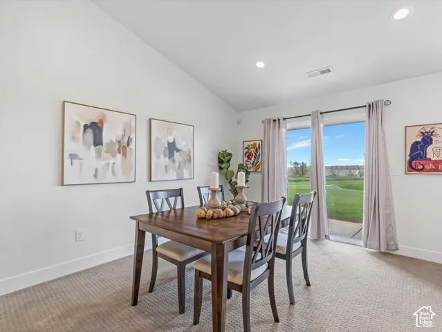 Vaulted ceiling, recessed lighting, sliding glass door, patio access, and carpeted flooring