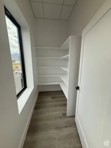 Integrated built-in shelving, wood-finish flooring, and a large window
