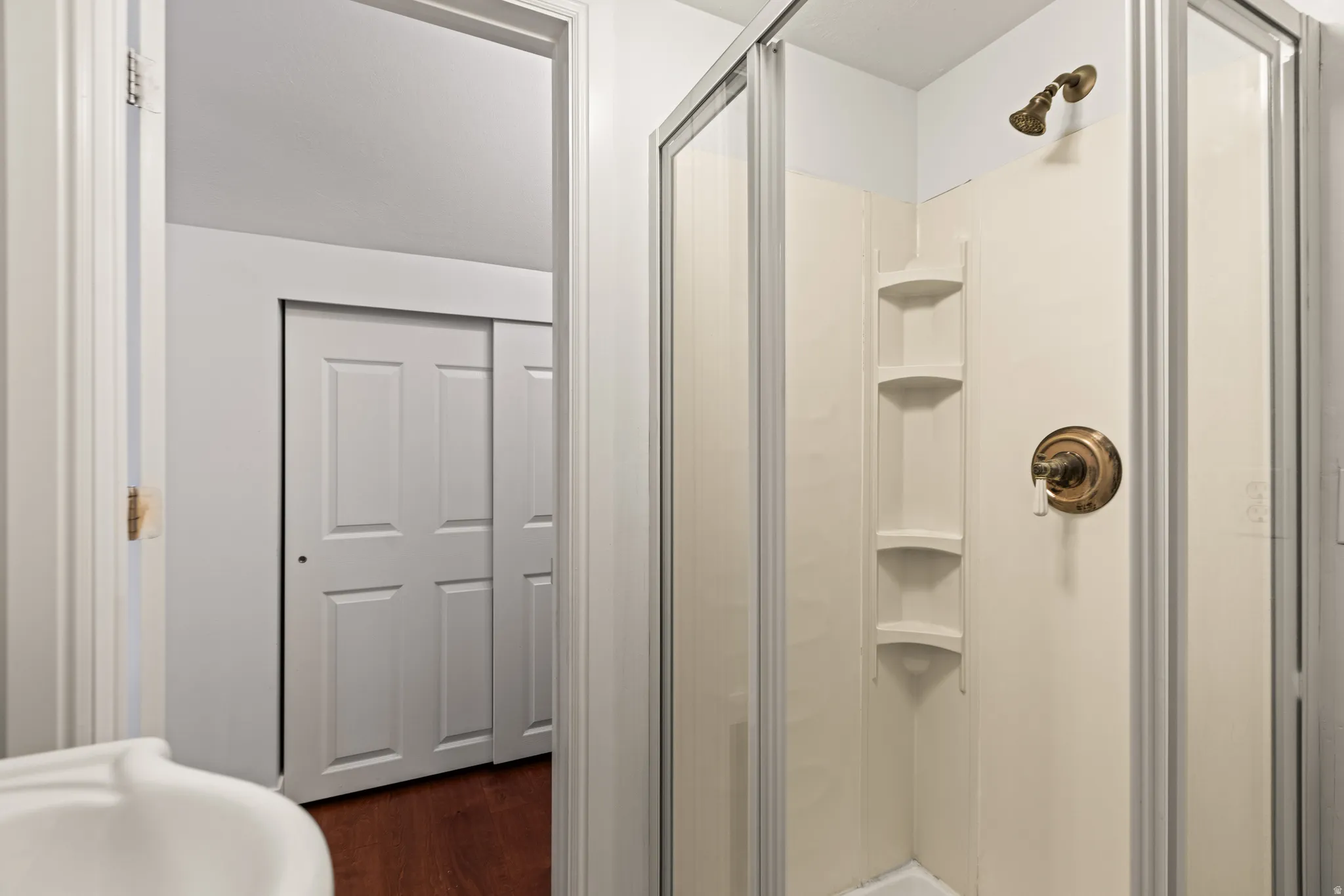 Shower enclosure with a bronze-finish shower head and control