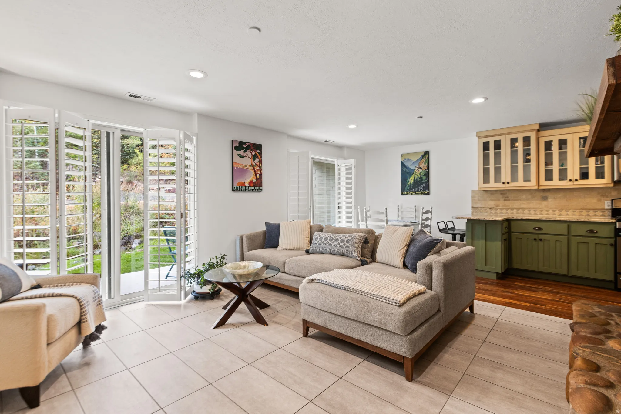 Recessed lighting, tile flooring, glass sliding doors with plantation shutters, wood-finish flooring, and built-in cabinetry