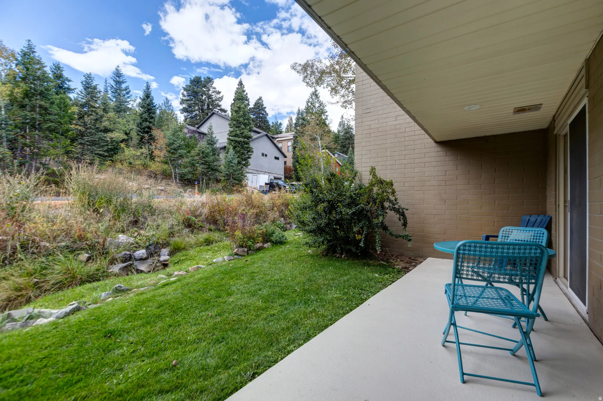 Covered patio with a concrete surface, a brick exterior wall, and a sliding glass door