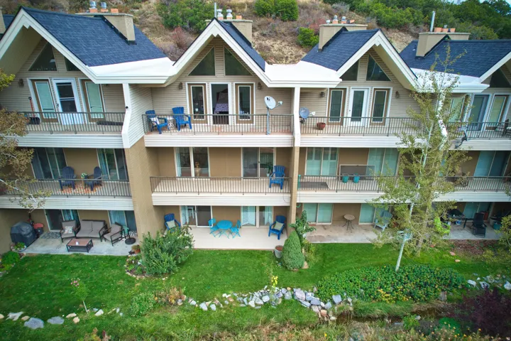 Multi-level townhome featuring multiple balconies, patio spaces, and gabled roofs