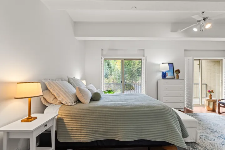 Wood-finish flooring, white walls, and a ceiling fan with integrated lighting