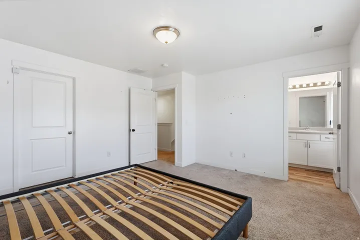 Neutral wall paint with carpet flooring, flush-mount ceiling light, and white paneled doors