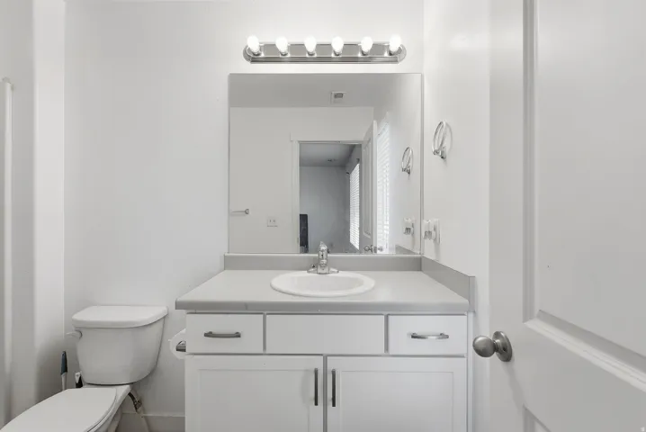 Vanity with an integrated sink, built-in cabinetry, and wall-mounted lighting fixture