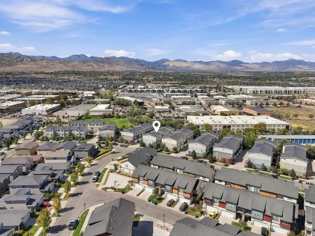 Townhome community with varied exterior finishes, established street trees, and mountain backdrop