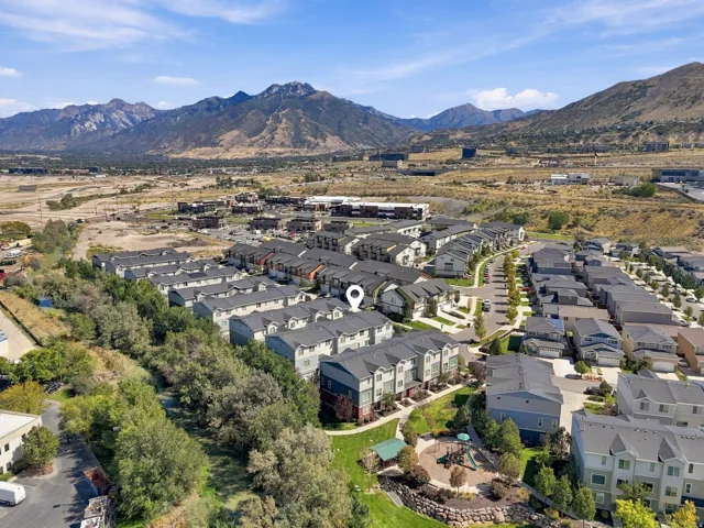 Townhome community with mountain backdrop, nearby playground, and mature trees