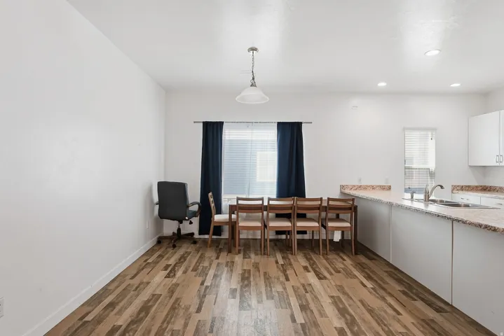 Open-concept living space featuring wood-finish flooring, white walls, and recessed lighting