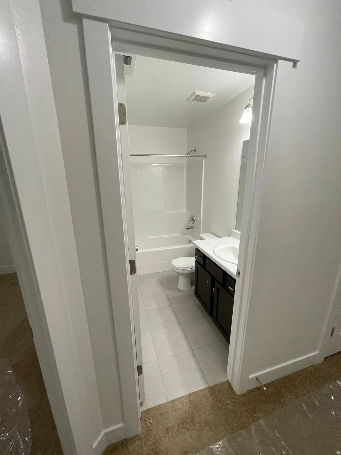 Bathroom featuring a single vanity with dark wood-finish cabinetry, white countertop, and integrated sink