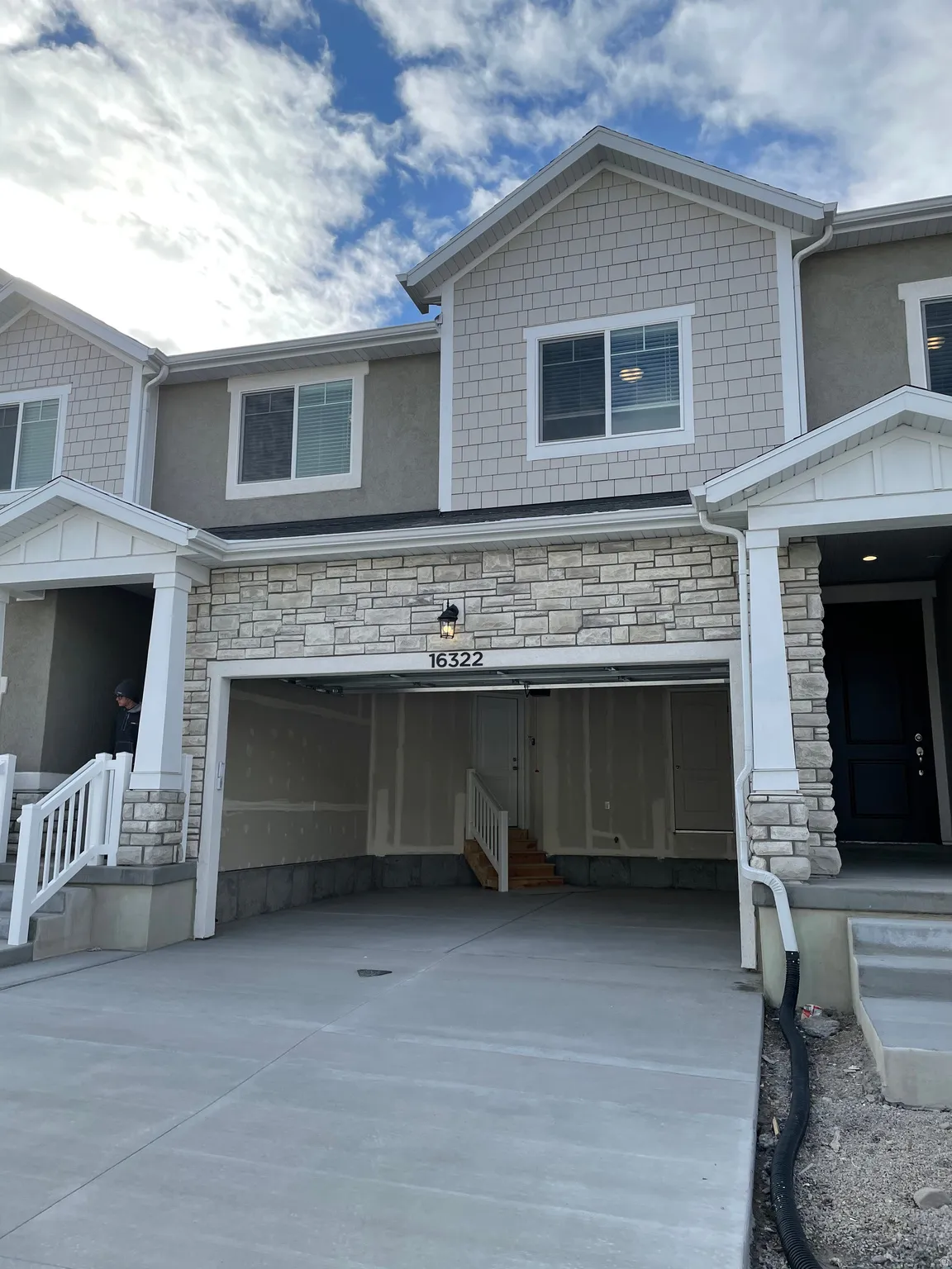 Modern townhome exterior with stone veneer accents, shingle siding, and stucco finishes