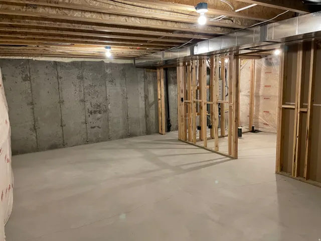 Unfinished basement with concrete flooring and exposed ceiling joists