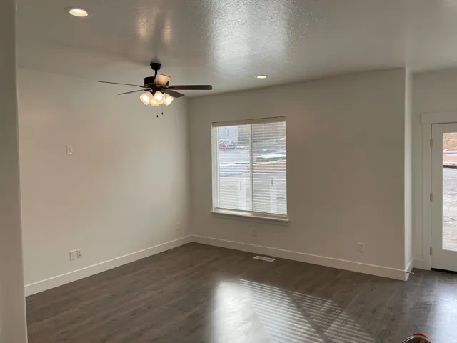 Spacious room featuring wood-finish flooring, recessed lighting, and a ceiling fan