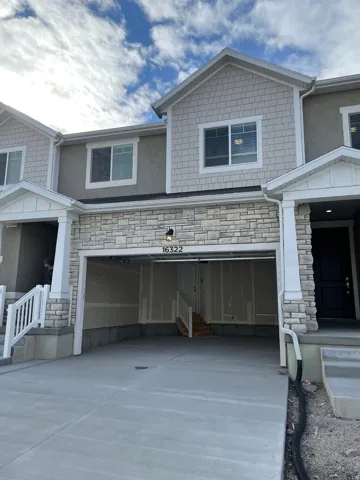 Modern townhome exterior with stone veneer accents, shingle siding, and stucco finishes