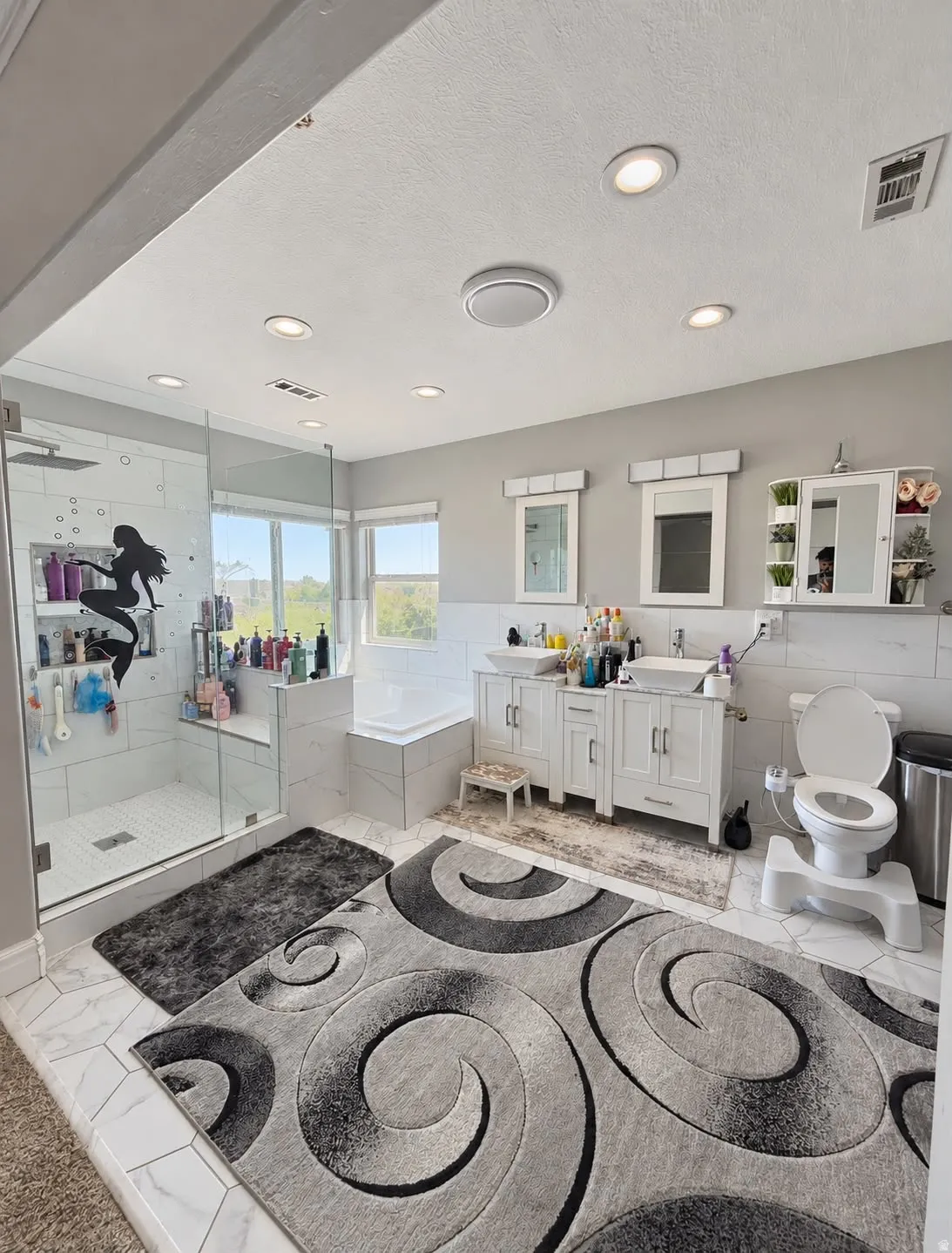 Tiled flooring, dual vanity with undermount sinks, glass-enclosed shower, built-in bathtub, and recessed lighting