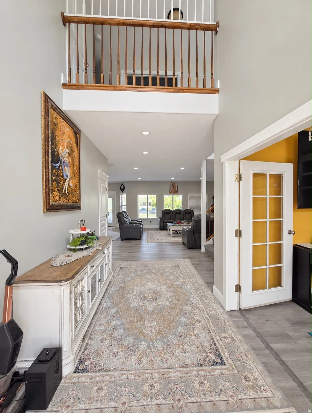 Two-story foyer with an open balustrade, recessed lighting, and wood-finish flooring