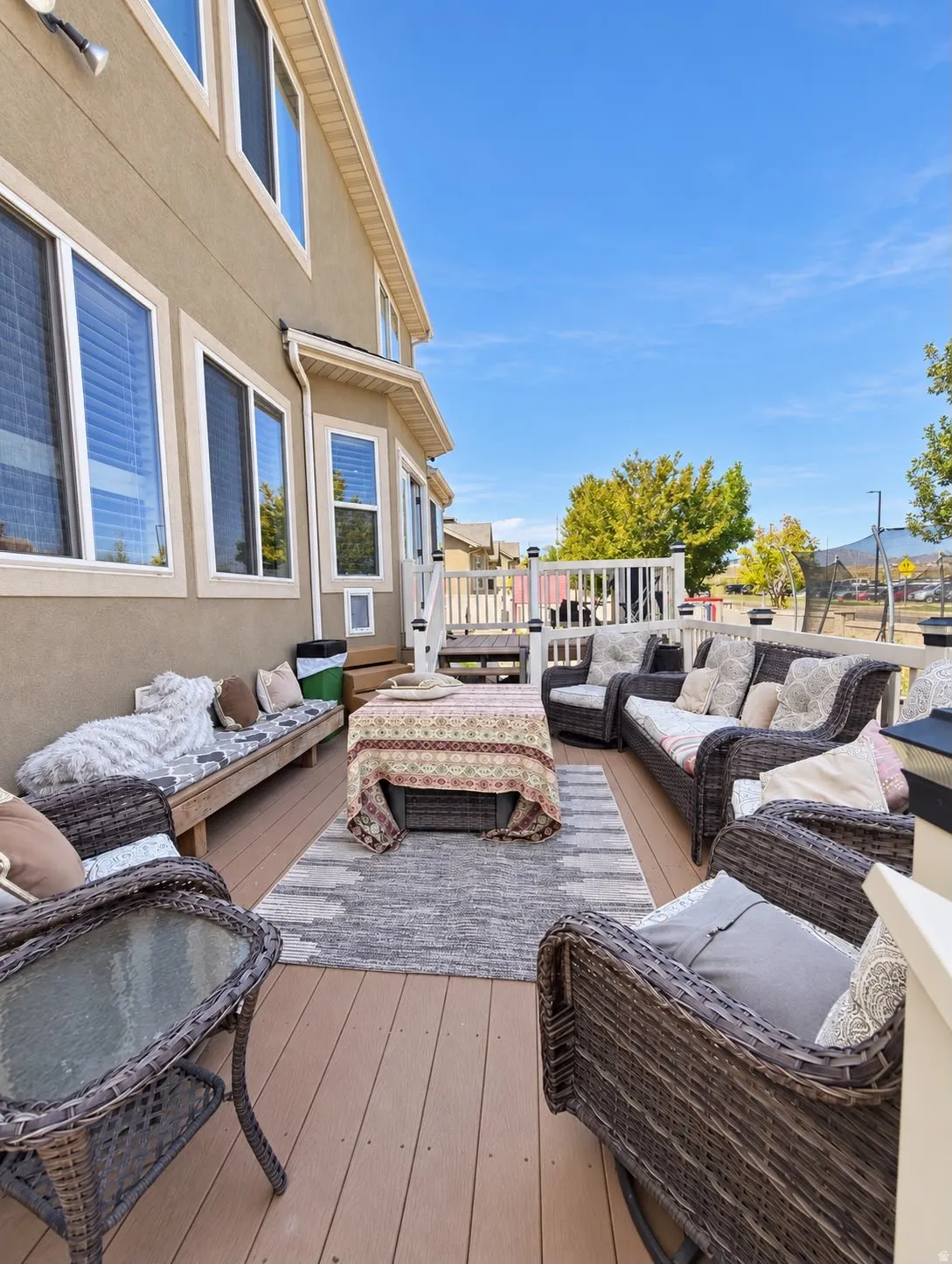 Expansive outdoor deck featuring wood-finish decking, white railings, and a built-in wooden bench