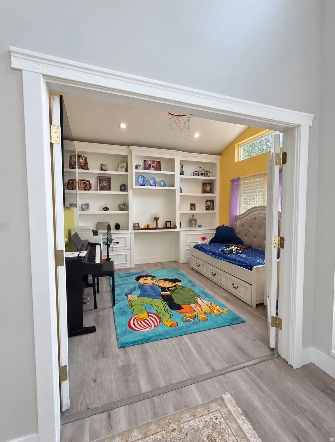 Built-in shelving with integrated desk, vaulted ceiling, recessed lighting, and wood-finish flooring