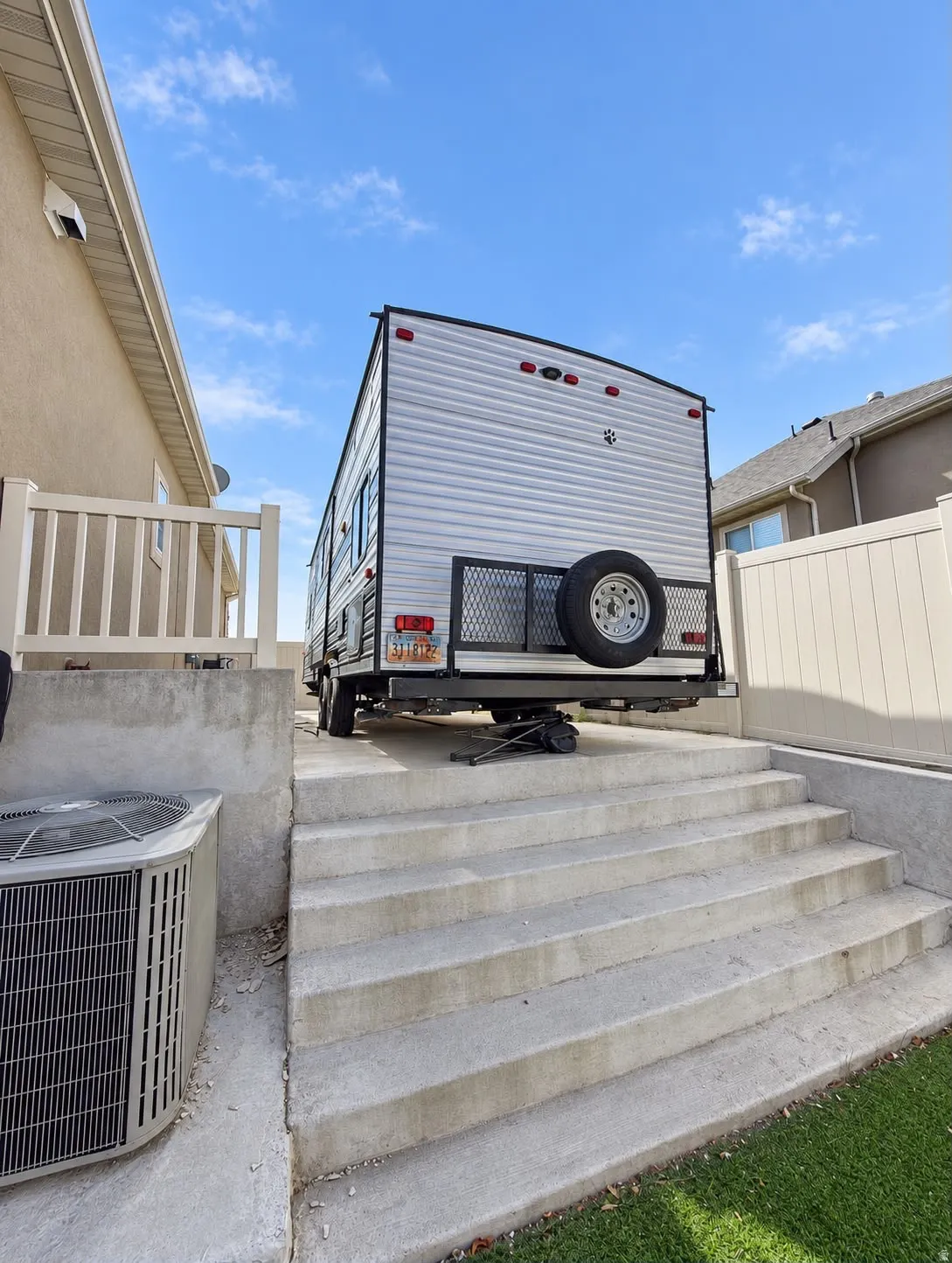 Concrete steps with a grassy border and an exterior air conditioning unit