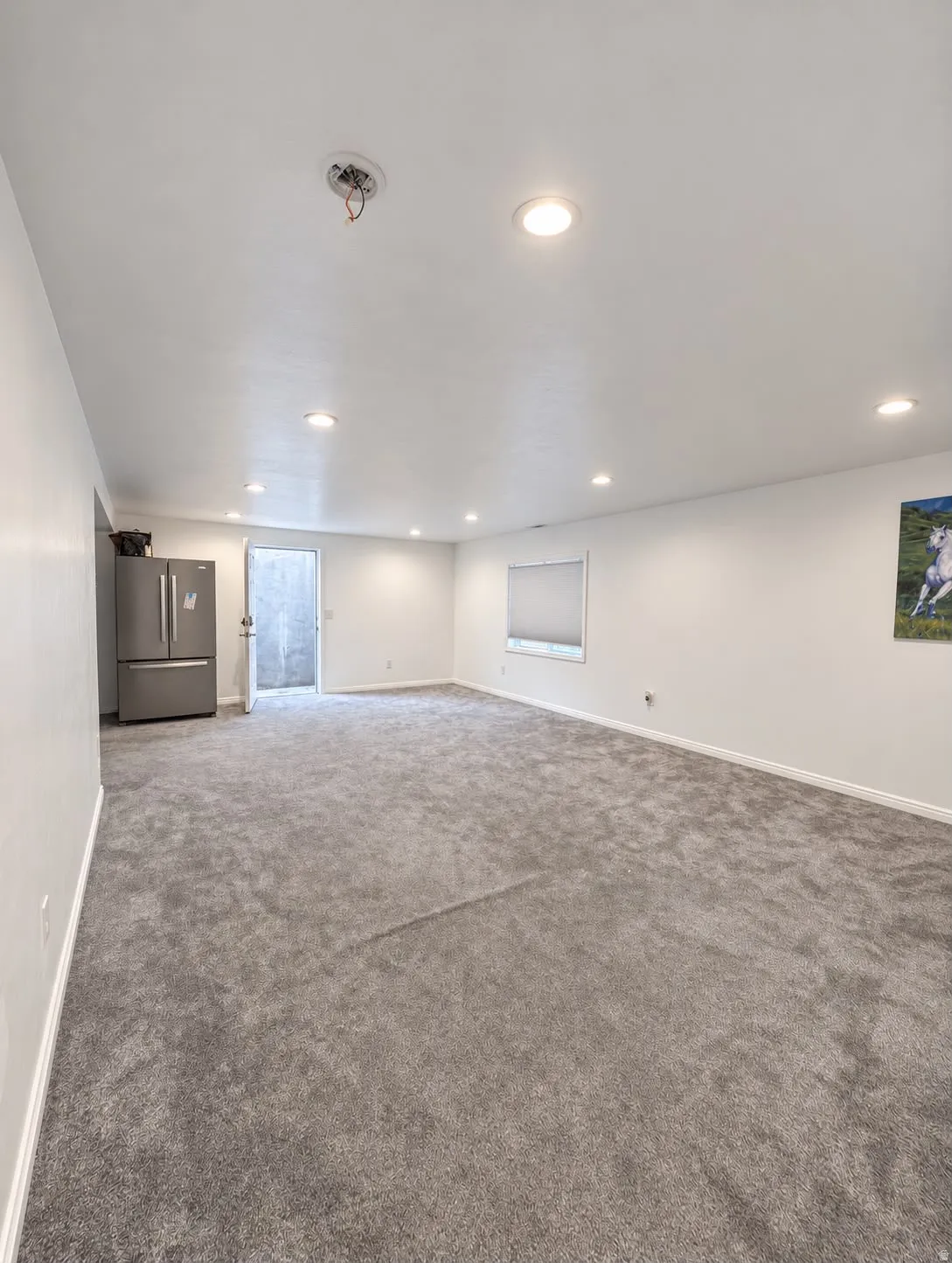 Spacious room with recessed lighting, light gray carpeting, and white walls